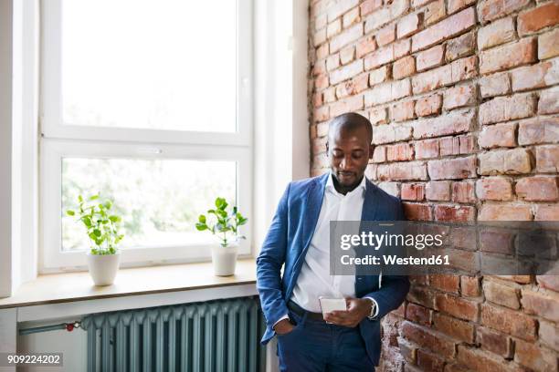 businessman using cell phone at brick wall by the window - brick phone stock pictures, royalty-free photos & images