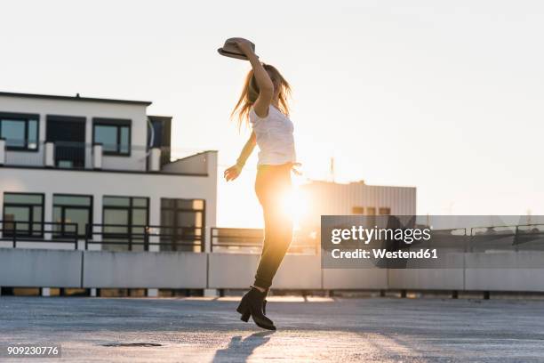 happy young woman on parking level in the city at sunset - free and parking stockfoto's en -beelden