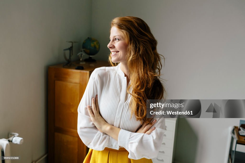 Smiling young woman in office looking sideways