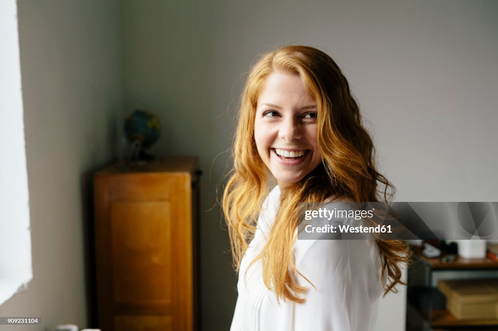Portrait of happy young woman in office