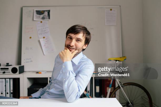 portrait of smiling businessman at desk in office - founder stock pictures, royalty-free photos & images