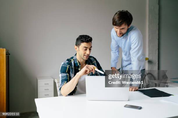 two businessmen with laptop at desk in office discussing - founder stock pictures, royalty-free photos & images
