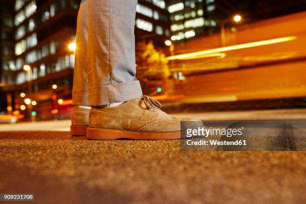 feet of businessman standing at roadside in the city at night, close-up - suede shoe stock pictures, royalty-free photos & images