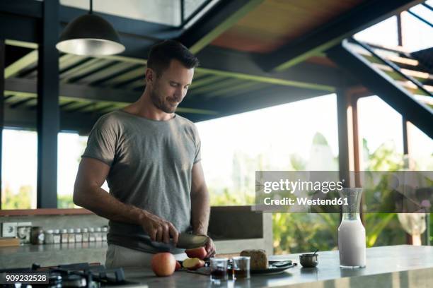 man preparing breakdast with milk, bread and fruit - vollkornbrot stock-fotos und bilder