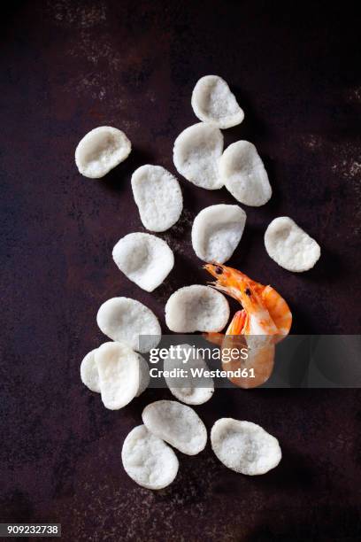 prawn crackers and shrimps on dark ground - prawn crackers stock pictures, royalty-free photos & images