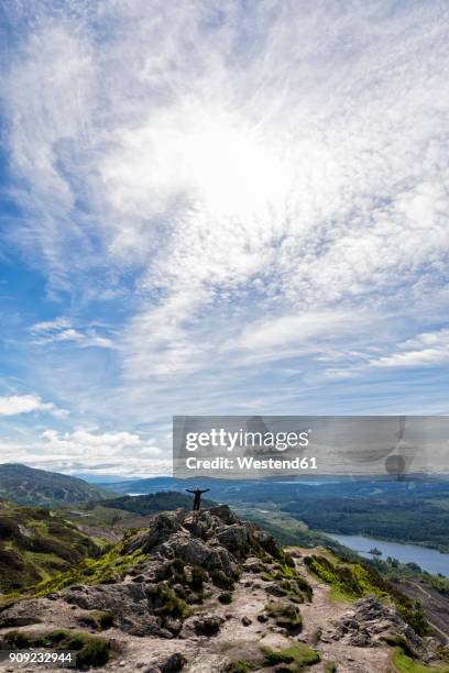 uk, scotland, highland, trossachs, tourist cheering on mountain ben a'an with view to loch katrine - meta turistica fotografías e imágenes de stock