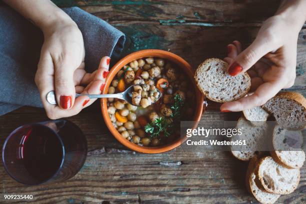 woman eating mediterranean soup with bread, close-up - bean stock-fotos und bilder