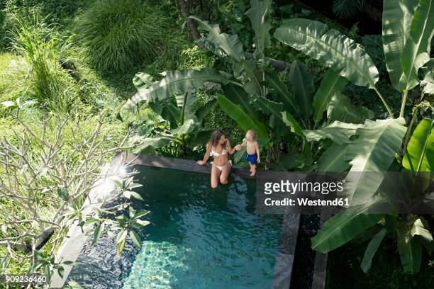 mother and son sitting by the poolside - bali luxury stock pictures, royalty-free photos & images