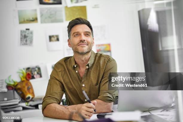 portrait of smiling man at desk in his office - portrait of handsome man stock pictures, royalty-free photos & images