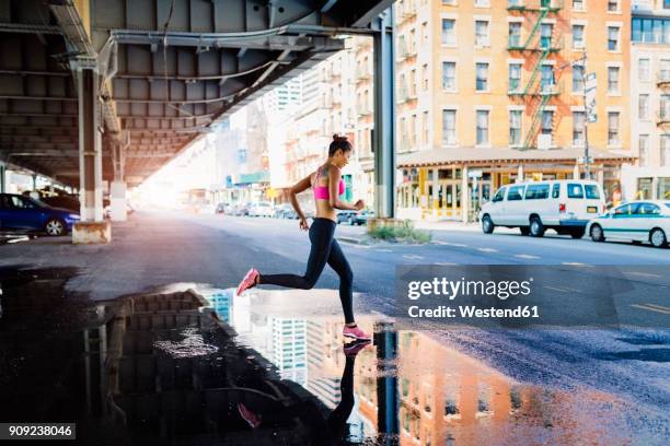 woman training in the morning in manhattan near brooklyn bridge - man running city stock-fotos und bilder