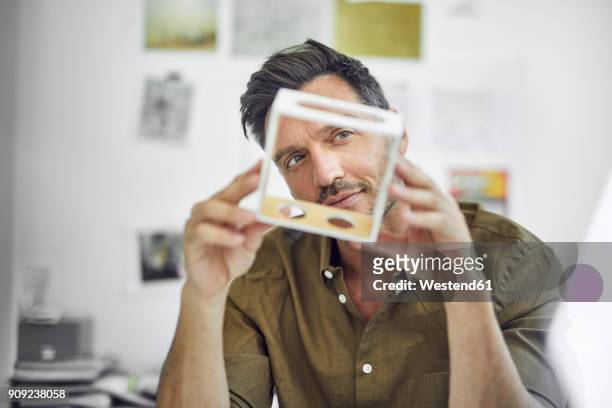 portrait of man checking component in his office - kreativität stock-fotos und bilder