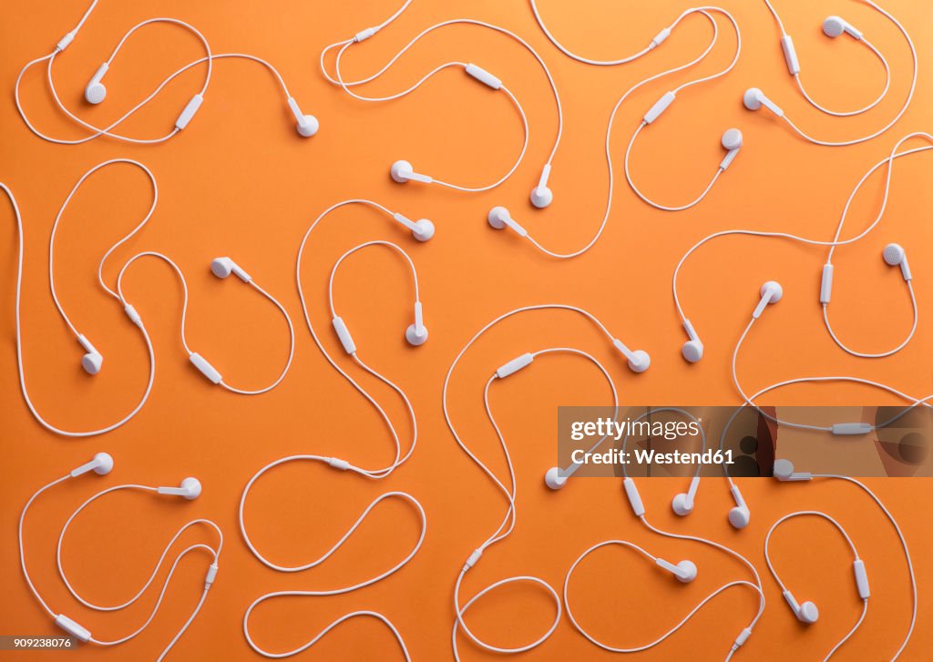 White earphones on orange background, 3D Rendering