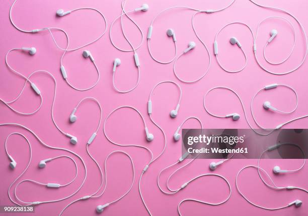 white earphones on pink background, 3d rendering - in ear headphones stock pictures, royalty-free photos & images