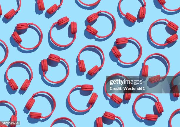 collection of red wireless headphones on light blue background, 3d rendering - coloured-background stock illustrations