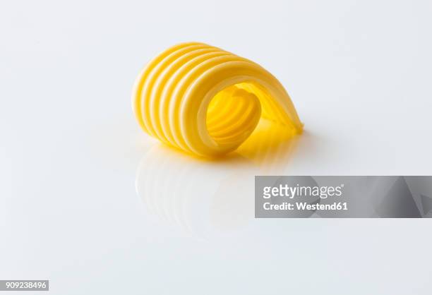 curl of butter on white ground - butter stock-fotos und bilder