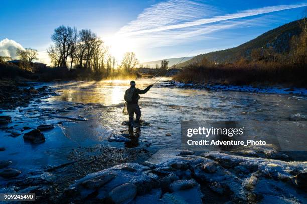 fly fisherman winter fishing - casting stock pictures, royalty-free photos & images