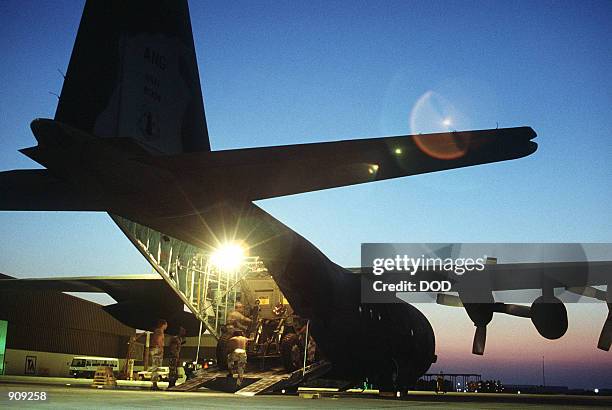 Crew of the 181st Tactical Airlift Squadron, Texas Air National Guard, load equipment of the 435th Airlift Control Element onto a C-130 Hercules...