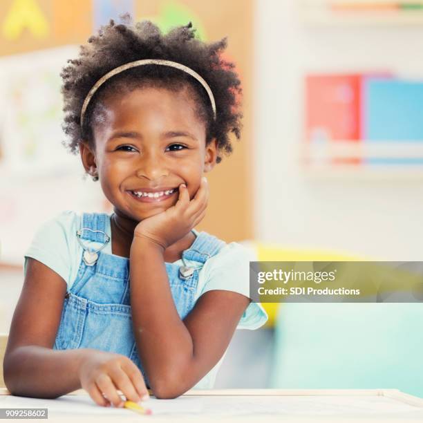 porträt von liebenswert vorschulkind in ihrem klassenzimmer - cute young black girls stock-fotos und bilder