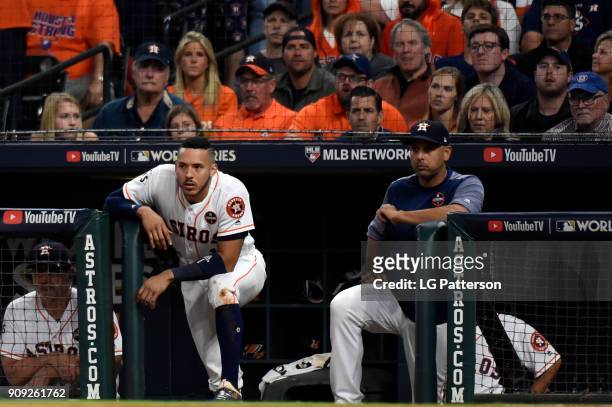 Carlos Correa and hitting coach Alex Cora of the Houston Astros look on from the dugout during Game 3 of the 2017 World Series against the Los...