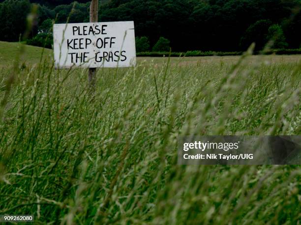 please keep off the grass sign on a field of long grass, coniston, cumbria, uk - keep off the grass sign stock pictures, royalty-free photos & images