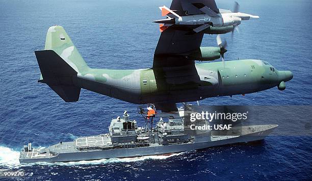 Hercules drone control aircraft banks to the left while passing over the guided missile cruiser USS CHOSIN . Members of the 6514th Test Squadron will...