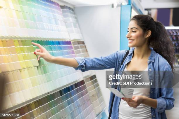 excited new home owner picks out paint color - denim store stock pictures, royalty-free photos & images