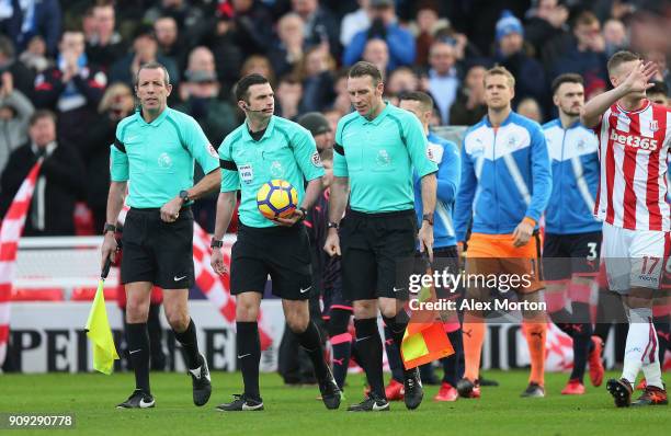 Match officials lead the teams out prior to the Premier League match between Stoke City and Huddersfield Town at Bet365 Stadium on January 20, 2018...