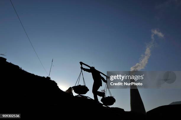 Migrant worker from India, carries mixed soil at a brick factory in Lalitpur, Nepal on Tuesday, January 23, 2018.