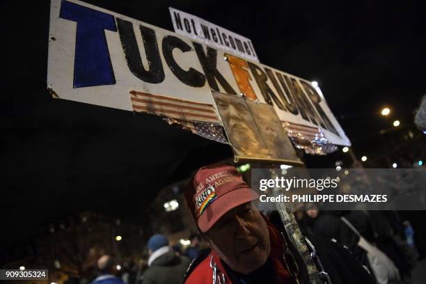 Protester holds up a banner during a protest against the attendance of the US president to the upcoming World Economic Forum in Davos, on January 23...