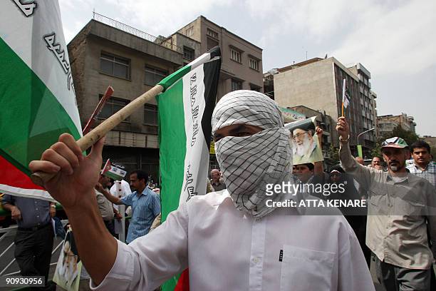 Iranian hardliners, waving Palestinian flags and portraits of the Islamic republic's supreme leader Ayatollah Ali Khamenei, protest during a rally...