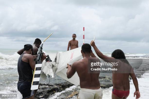 Residents help firefighters and rescue a part of the helicopter's propeller, in Recife, Northeast Brazil, on January 23, 2018. A helicopter from the...