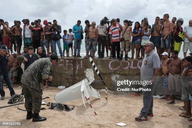 Police specialists and the local population observe part of the helicopter propeller in Recife, Northeast Brazil, on January 23, 2018. A helicopter...