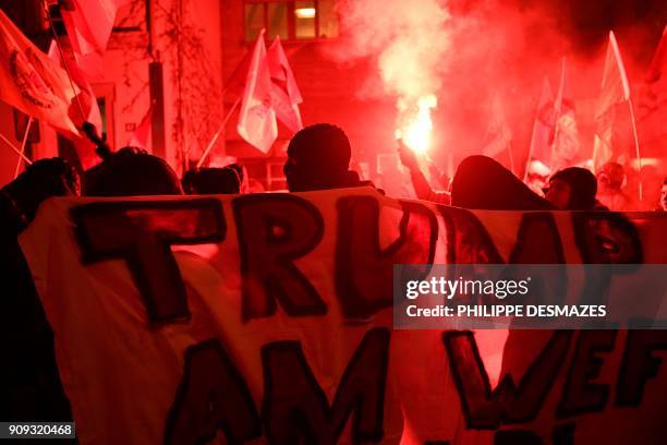 Flare is lit as people protest against the attendance of the US president to the upcoming Davos World Economic Forum, on January 23 in central...