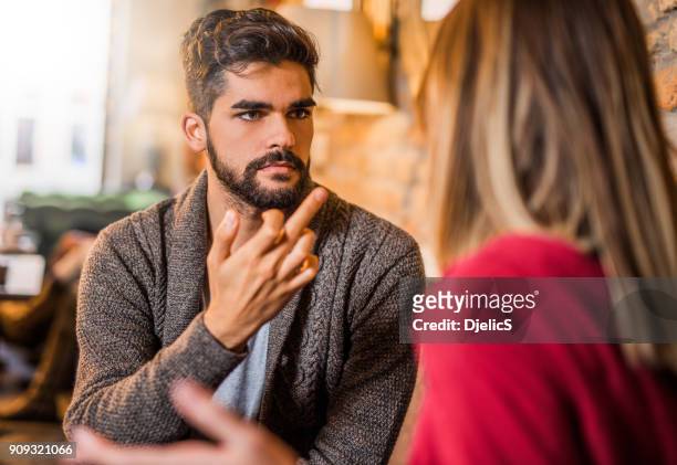 zorniger junger mann zeigt ein mittelfinger zu seiner freundin. - portrait woman men looking at each other stock-fotos und bilder