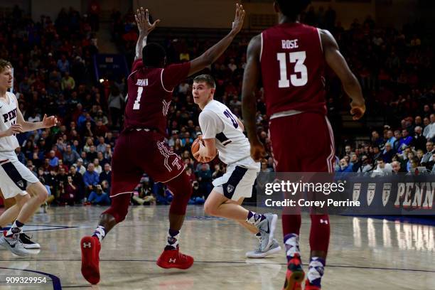 Ryan Betley of the Pennsylvania Quakers looks to pass in the final seconds against Josh Brown and Quinton Rose of the Temple Owls during the second...