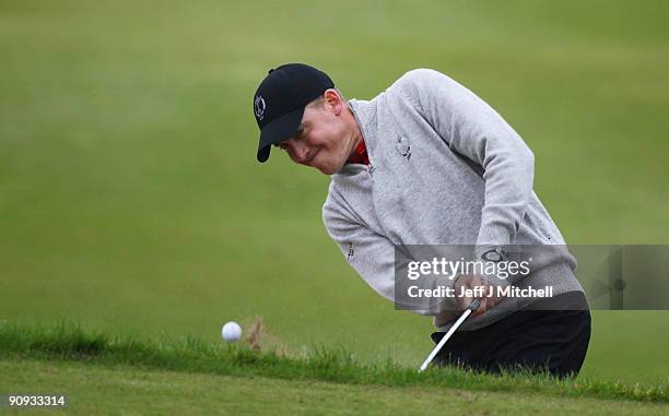 Will Barnes of Great Britain play's out the bunker on the 13th green in the morning foursome matches at The Carrick on Loch Lomond on September 18,...