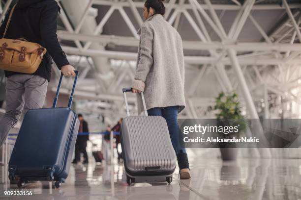 jong koppel aankomst op de luchthaven - terugkomdag stockfoto's en -beelden