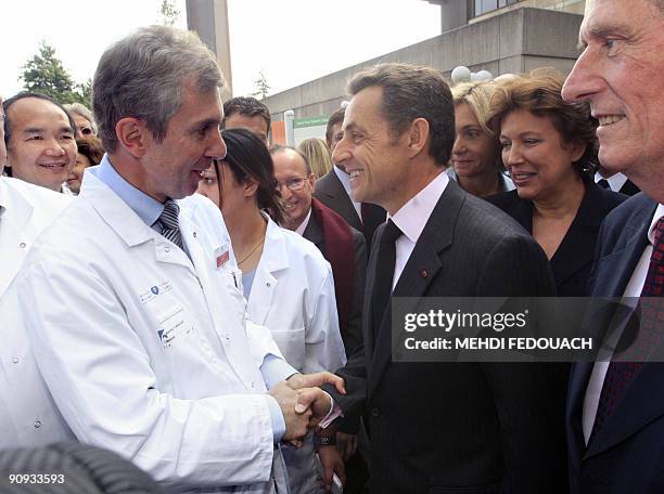 French President Nicolas Sarkozy , flanked by French Health and Sports minister, Roselyne Bachelot , salutes French surgeon and researcher, Rene Adam...