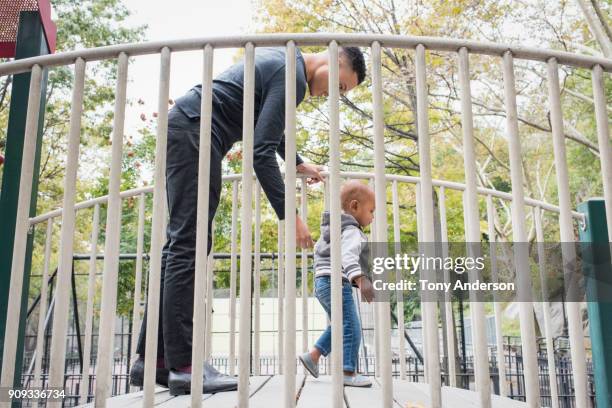 Young father playing with infant daughter in city park