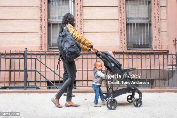 young mother walking with infant daughter in the city - pushchair fotografías e imágenes de stock