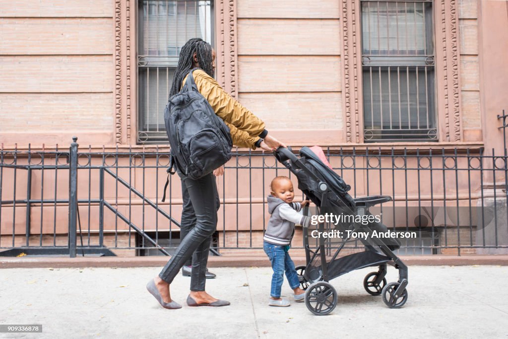 Young mother walking with infant daughter in the city
