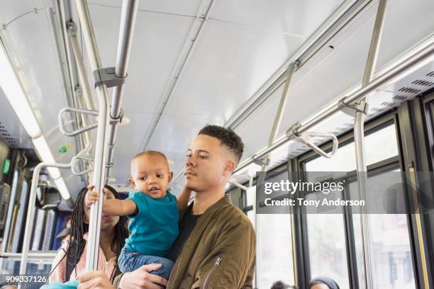 young mother father and infant riding city bus - pole positie fotografías e imágenes de stock