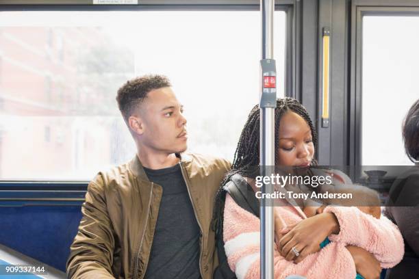 Young mother father and infant riding city bus