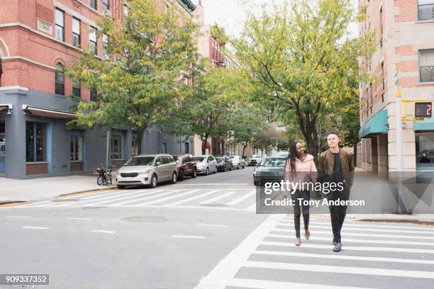 young couple walking in the city - crossing road stock pictures, royalty-free photos & images