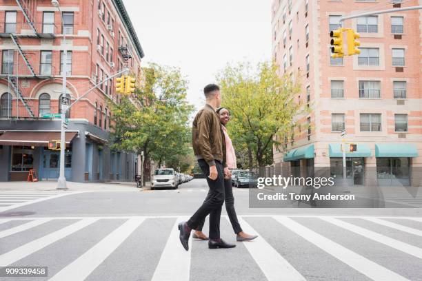 young couple walking in the city - attraversamento pedonale foto e immagini stock