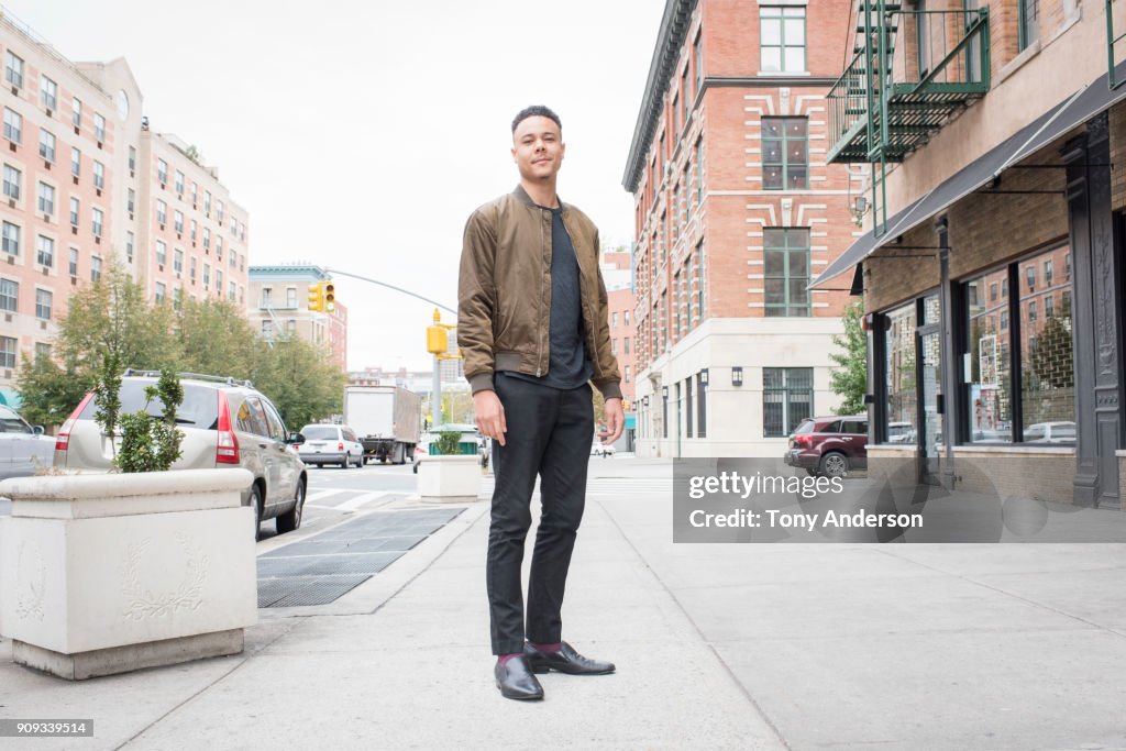 Young man standing on city sidewalk