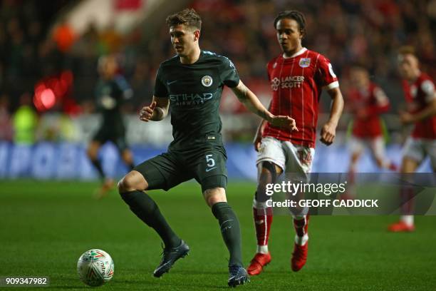 Manchester City's English defender John Stones controls the ball under pressure from Bristol City's English striker Bobby Reid during the English...