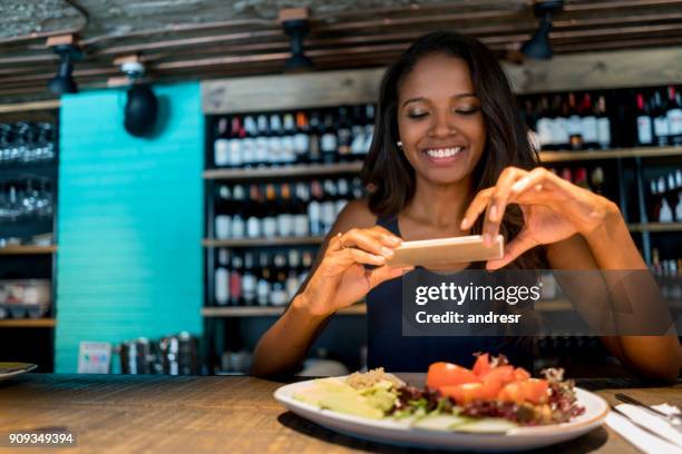 woman taking a picture of her food at a restaurant - african dining stock pictures, royalty-free photos & images