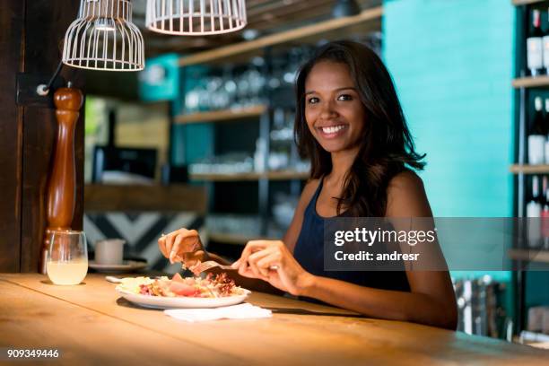 happy woman eating at a restaurant - african dining stock pictures, royalty-free photos & images