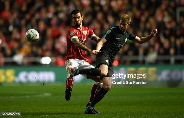 Bristol defender Aden Flint challenges Kevin De Bruyne during the Carabao Cup Semi-Final: Second Leg match between Bristol City and Manchester City...